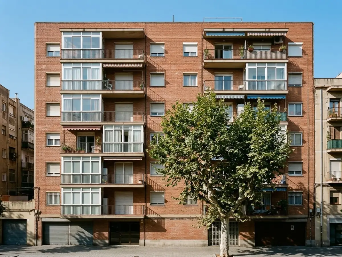 Fachada de un bloque de pisos de ladrillo con varios balcones cerrados con aluminio del mismo color
